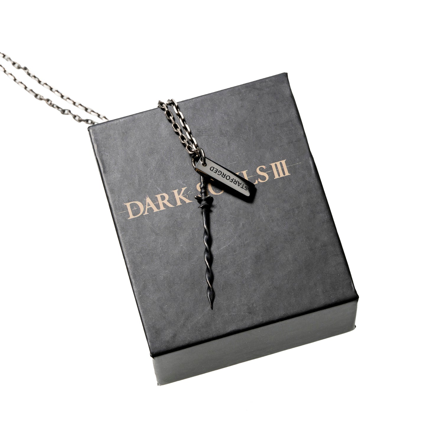 Sword missing from the shrine bonfire.
Cannot be equipped as a weapon.Thrust into the shrine bonfire to restore its power and enable travel between bonfires.This sword is only bequeathed to chosen ash, as judged by the Iudex, who awaits the arrival of ash as a scabbard.

PRODUCT PARAMETER
Brand: STARFORGED (Licensed by Bandai Namco Entertainment Inc.)
Name: Coiled Sword Pendant
Material: 925 Silver
Size: Height 49.6 mm × Width 7.8 mm
Weight: Approx. 1.2 g
Note: Color variations may occur due to lighting con